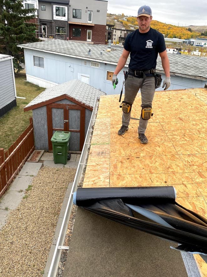 Roofer applying underlay on a new roof in calgary