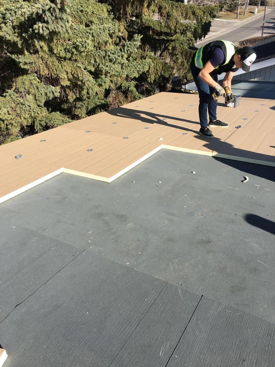 man installing flat roof installation in Calgary